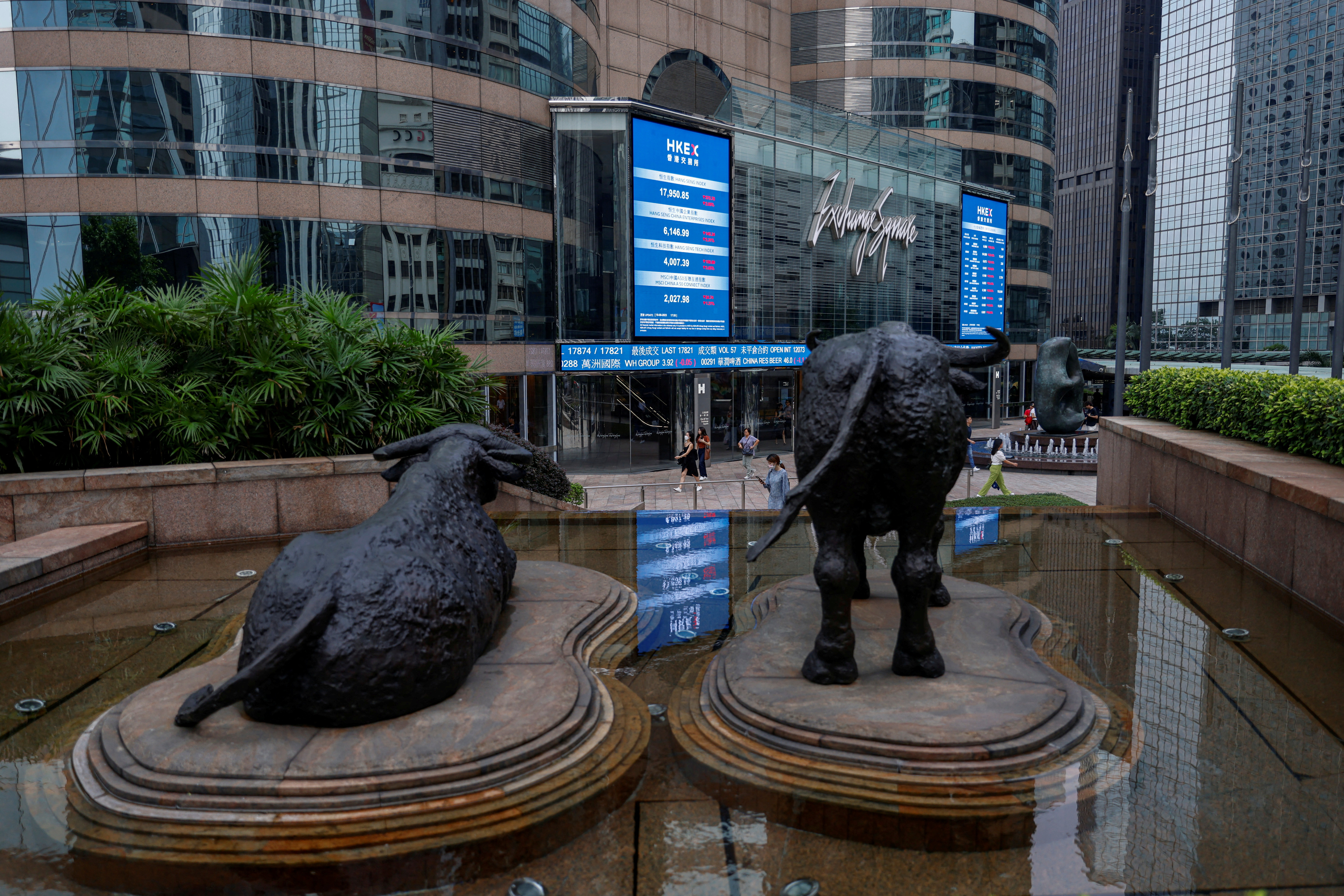 يتم وضع تماثيل الثور في خط الشاشات التي تظهر مؤشر أسهم Hang Seng وأسعار الأسهم خارج ساحة Exchange ، في هونغ كونغ