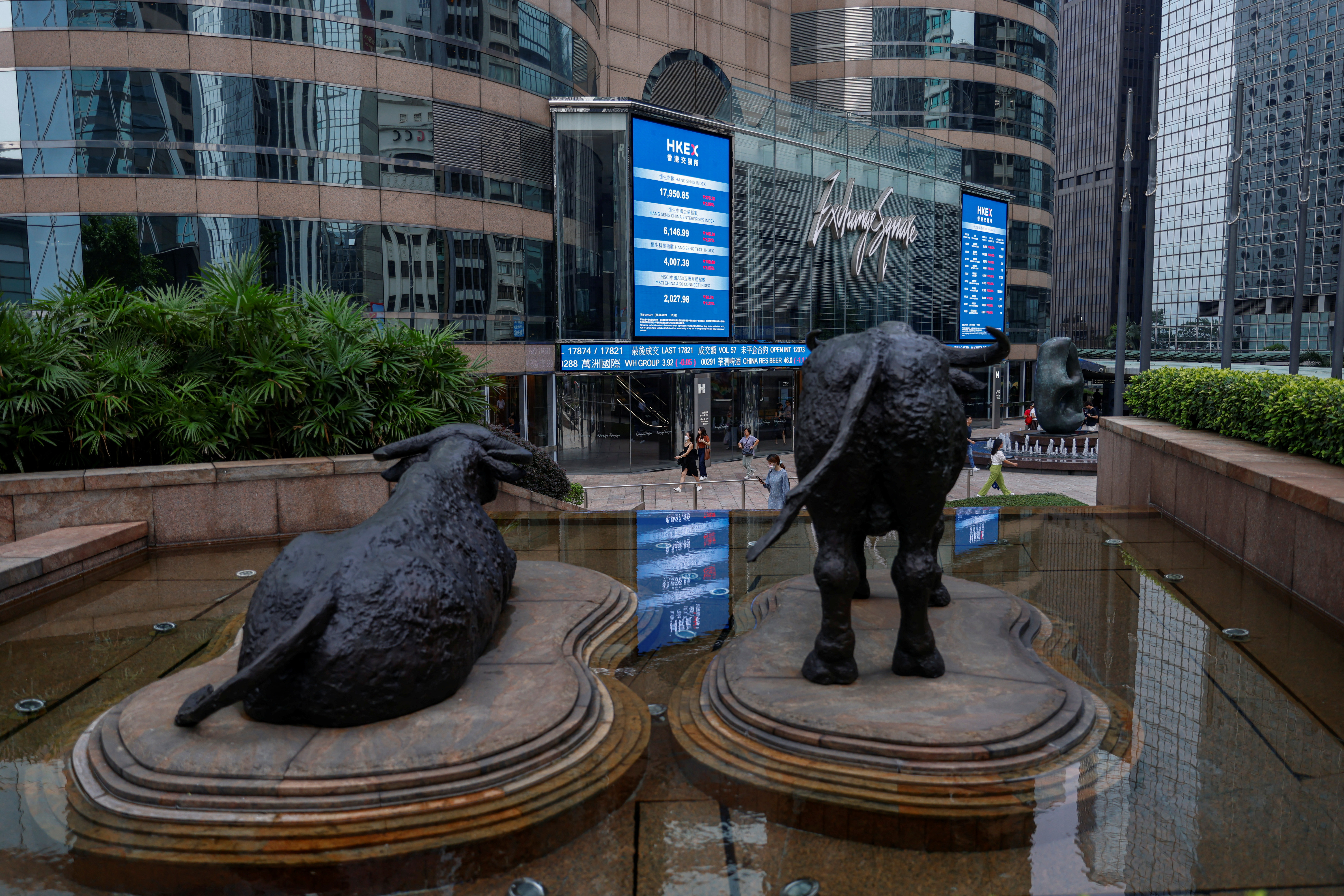 يتم وضع تماثيل الثور في خط الشاشات التي تظهر مؤشر أسهم Hang Seng وأسعار الأسهم خارج ساحة Exchange ، في هونغ كونغ