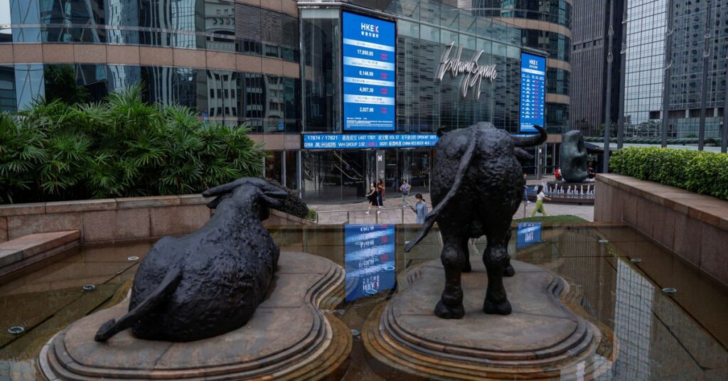 Bull statues are placed in font of screens showing the Hang Seng stock index and stock prices outside Exchange Square, in Hong Kong
