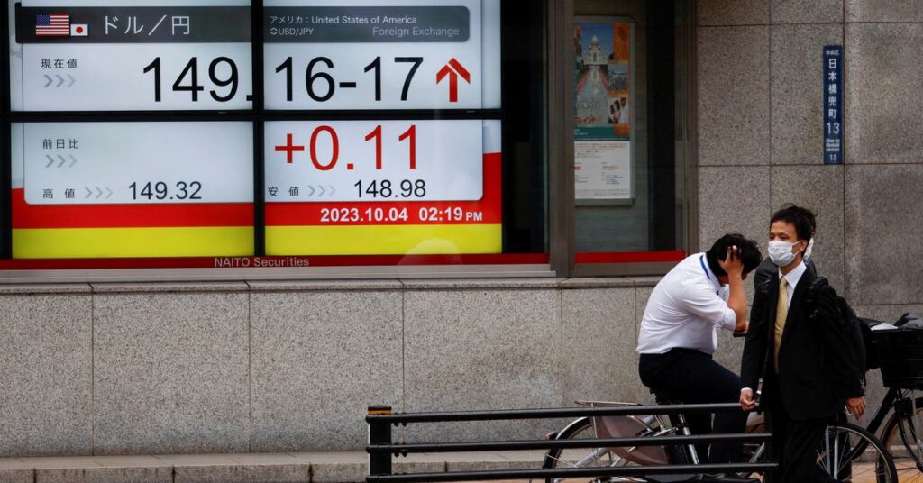 تراجعت الأسهم الآسيوية بسبب بيانات الصين الضعيفة ، وانخفض الين حيث قام بنك اليابان بتعديل السيطرة على العوائد Passersby walk past an electric monitor displaying the Japanese yen exchange rate against the U.S. dollar outside a brokerage in Tokyo