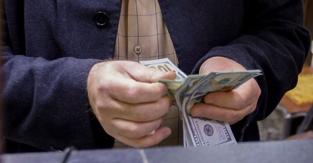 A man counts U.S. dollars at a currency exchange shop in Baghdad