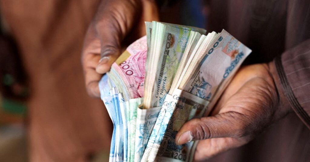 Man counts Nigerian naira notes in a market place in Yola