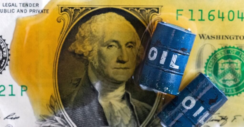 Illustration shows oil, miniatures of oil barrels and U.S. dollar banknote