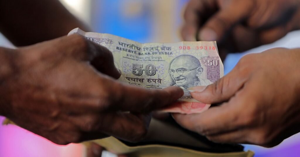 الروبية الهندية الهادئة في أكتوبر قد لا تستمر A customer hands a 50-Indian rupee note to an attendant at a fuel station in Ahmedabad