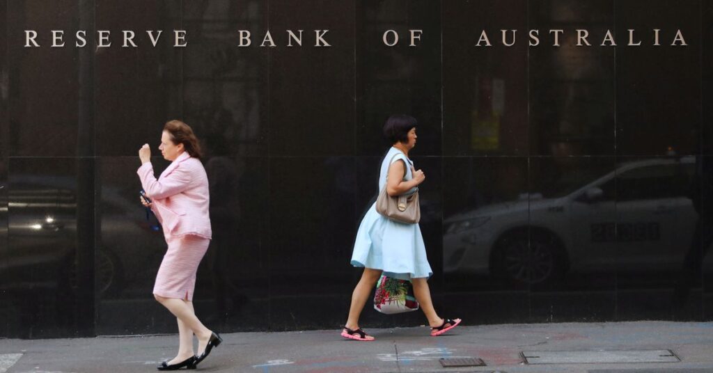 Two women walk next to the Reserve Bank of Australia headquarters in central Sydney