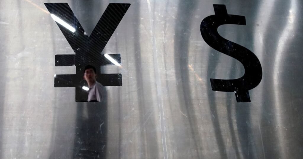 Signs of Chinese yuan and U.S. dollar are seen at a currency exchange store in Shanghai