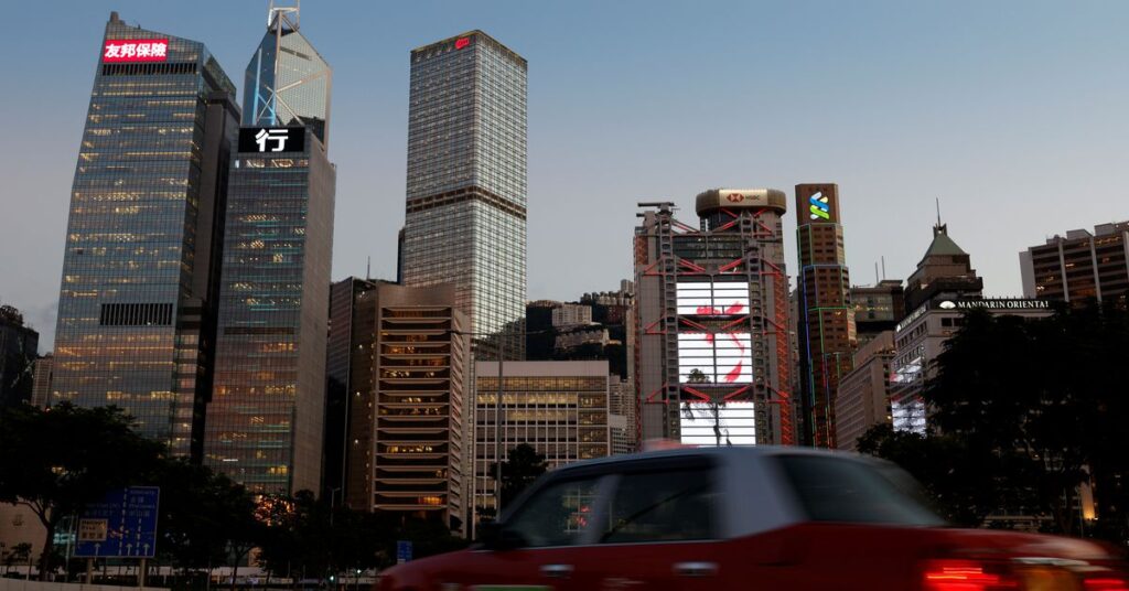 A taxi drives in front of skyscrapers at central business district in Hong Kong