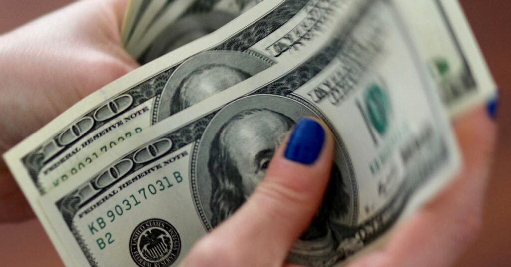 A woman counts U.S. dollar bills at her home in Buenos Aires