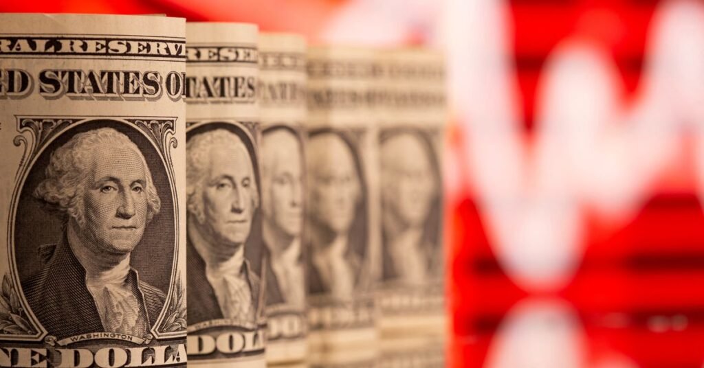 U.S. one dollar banknotes are seen in front of displayed stock graph in this illustration taken