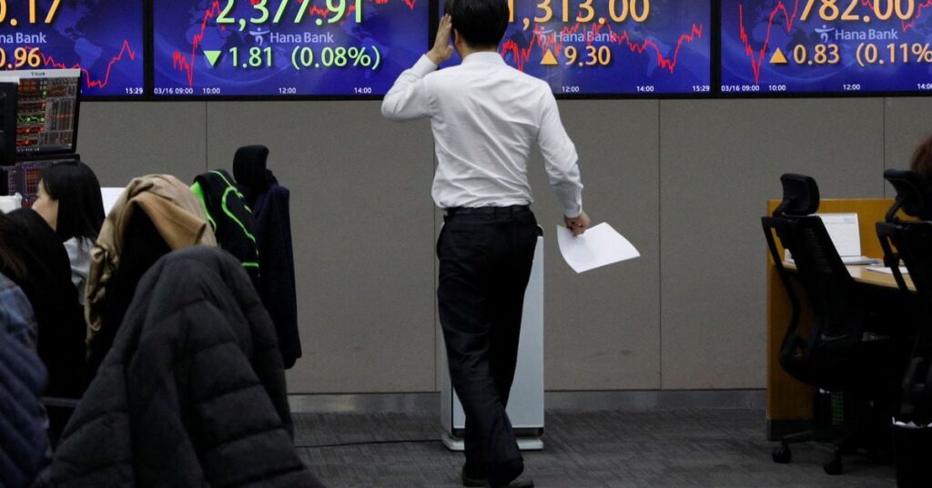 Currency dealers work in front of an electronic board showing the Korean Composite Stock Price Index  (KOSPI) at a dealing room of a bank, in Seoul
