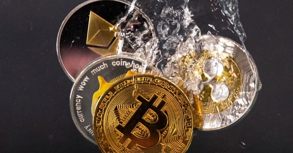 Souvenir tokens representing cryptocurrency networks Bitcoin, Ethereum, Dogecoin and Ripple plunge into water